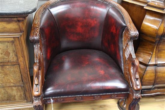 A pair of French Empire style carved mahogany and brass studded leather tub shaped armchairs,